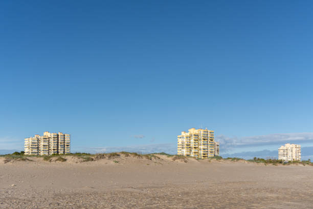 istock Three buildings behind the beach dunes 1357994986
