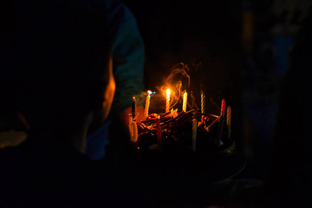 Blowing out candles on birthday cake with children in the background.Close up of candles blown on chocolate cake. Happy birthday concept. Candle smoke on homemade pie. Sweet holiday cake