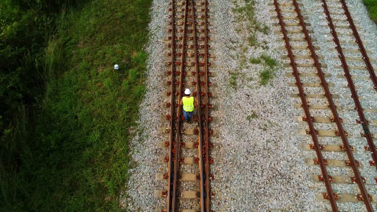 Arial view photo showing engineer under inspection and checking construction process railway switch and checking work on railroad station .Engineer wearing safety uniform and safety helmet in