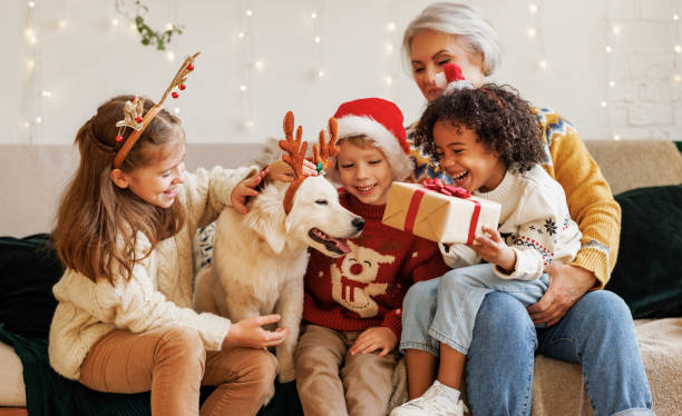 幸せな多民族家族、クリスマスの日を楽しむ孫と犬との祖母 - grandmother senior adult smiling women ストックフォトと画像