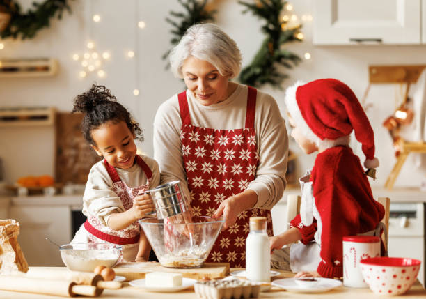 glückliche multirassische kinder helfen großmutter, in den winterferien weihnachtsplätzchen in der küche zu kochen - grandmother cooking baking family stock-fotos und bilder