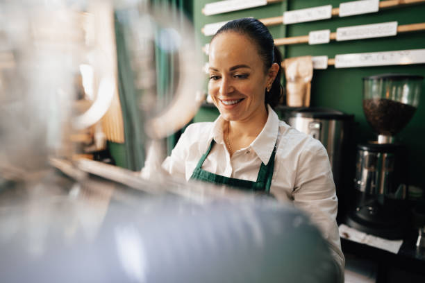 istock Caucasian female barista at work making coffee 1358002185