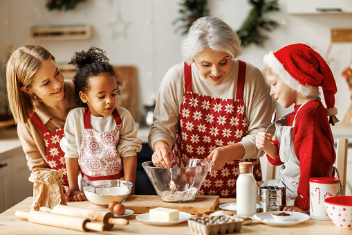 istock Happy multiethnic family, grandmother, mother and kids cooking together on Christmas day in kitchen 1358003243