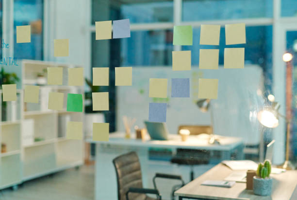 Still life shot of sticky notes on a glass screen in an empty office at night
