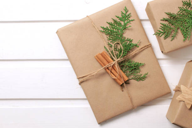 istock Gift boxes wrapped in craft paper with cinnamon stick on white background 1358003389