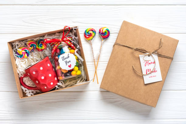 istock Handmade care package, seasonal gift box with candies, cup on white table Personalized eco friendly basket for family, friends, girl for thanksgiving, xmas, Christmas, mothers, fathers day Flat lay 1358004666