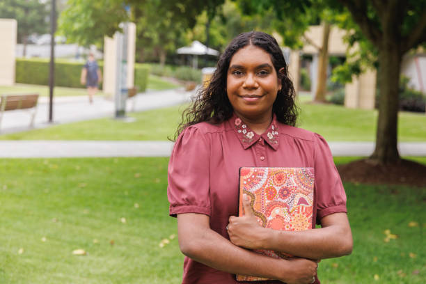 female aboriginal australian student holding laptop - australië stockfoto's en -beelden