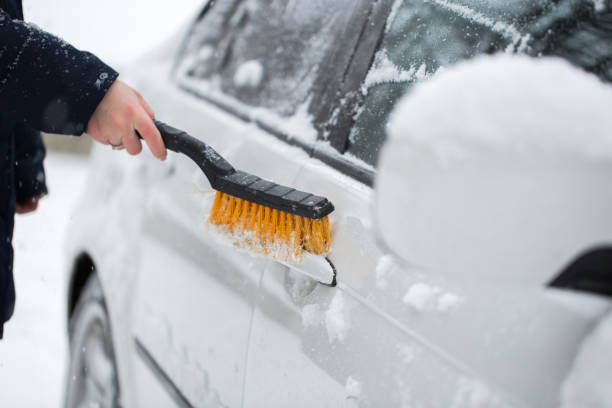 冬の車から雪を掃除する女性。車のハンドル。 - snow car window ice scraper ストックフォトと画像