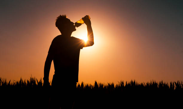 istock Silhouette of man at sunset, man drinks a water. 1358008197