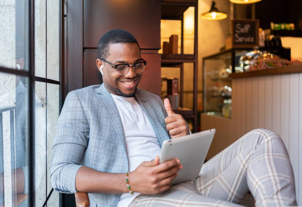 istock Man On A Video Conference Call At Coffee Shop 1358009661