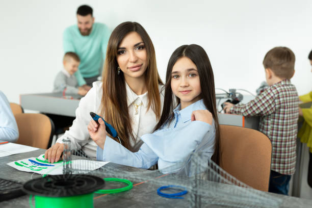 istock Lesson in the robotics hall. Mom and daughter use pen for 3D printing. Creative, technology, leisure, educational concept 1358011691