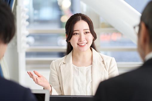 Mujer de negocios asiática explicando en una reunión photo