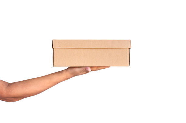 istock Hand holding brown paper parcel box  isolated on white background.Messenger bag for online shopping concept. 1358013974