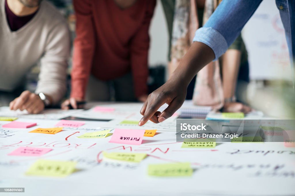 We need to focus on our future goals! Close-up of black entrepreneur and his business team brainstorming while analyzing mind map on a meeting in the office. Brainstorming Stock Photo