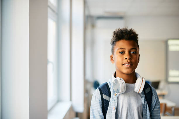 istock Portrait of black elementary student in the classroom looking at camera. 1358014311