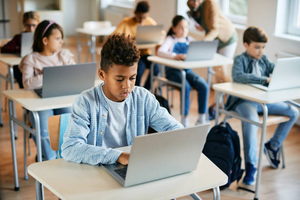 istock African American schoolboy e-learning on laptop during computer class in the classroom. 1358014312