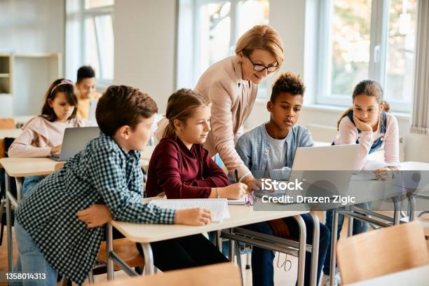 Group Of Elementary Students Having Computer Class With Their Teacher In The Classroom Stock Photo - Download Image Now