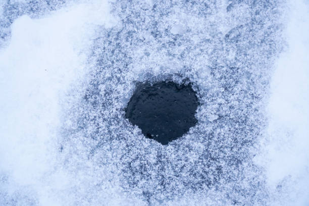 istock Ice hole in ice for winter fishing 1358016558