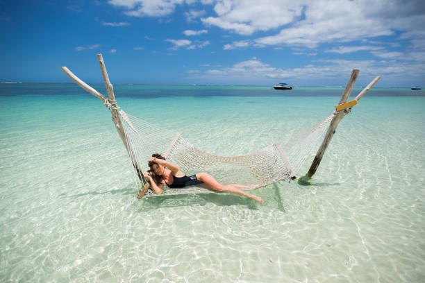 istock Woman in hammock on tropical beach at island 1358016763
