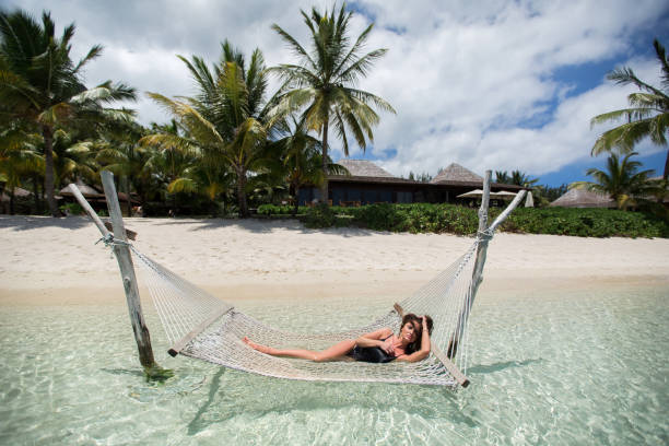 istock Woman in hammock on tropical beach at island 1358016850