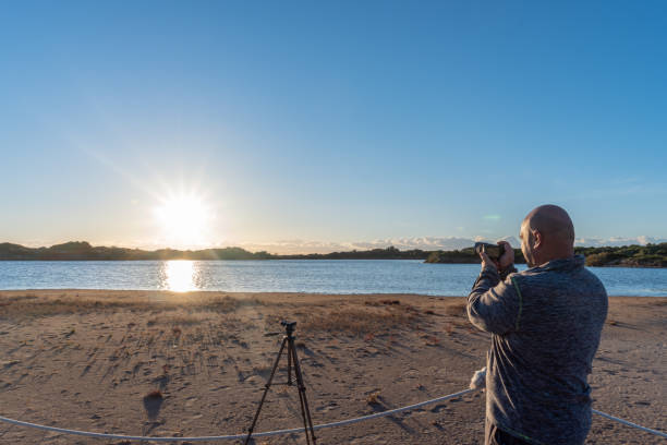 istock Man photographing sunrise over wetlands. 1358019078