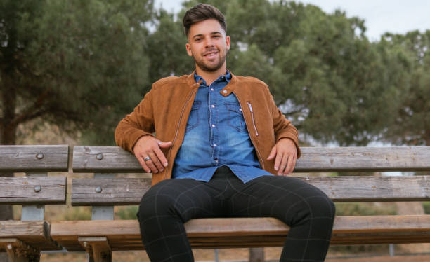 istock handsome guy in casual clothes sitting on a bench of a viewpoint 1358019689