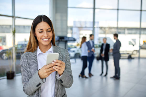 istock Young businesswoman using mobile phone and text messaging 1358022114