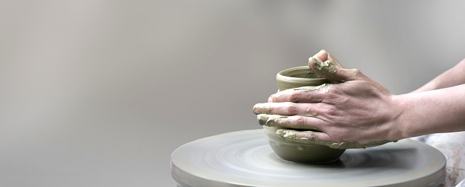 hands making ceramic cup on potter's wheel