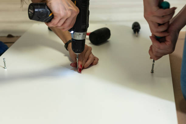 istock Assembling furniture at home by woman using electric screwdriver. 1358028088