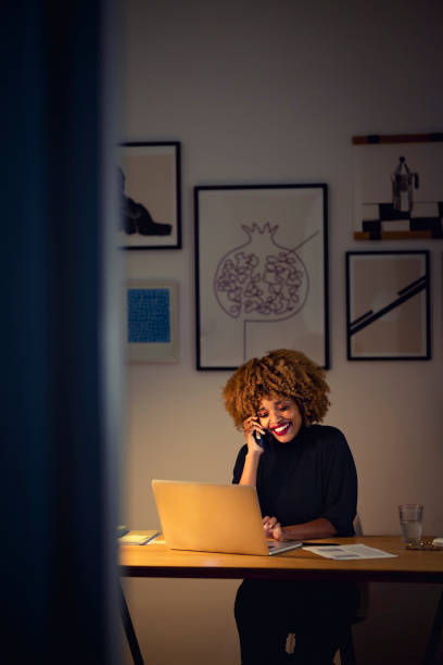 istock Happy Businesswoman Talking on a Mobile Phone at Night 1358029196