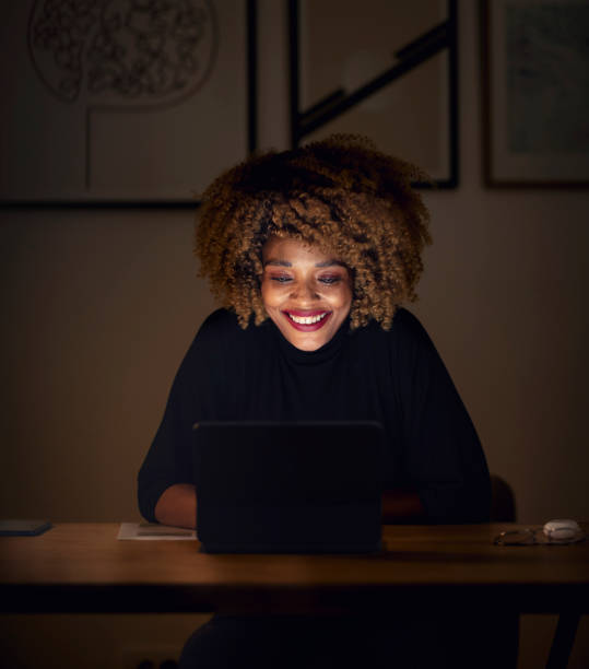 istock Smiling Businesswoman Using Digital Tablet at Night 1358029355