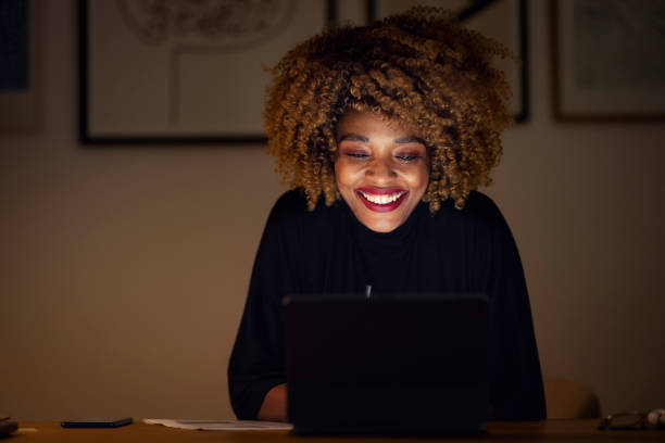 istock Smiling Businesswoman Using Digital Tablet at Night 1358029362