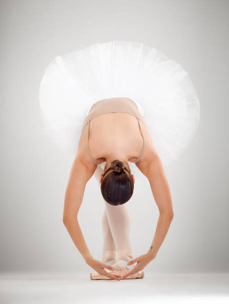Full length shot of an attractive young female ballet dancer in studio against a grey background And scene curtseying stock pictures, royalty-free photos & images