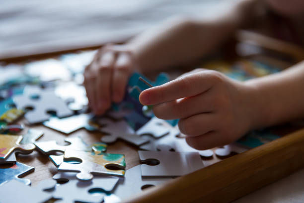 istock Children's hands collect puzzles. An educational game for a kid. 1358029804