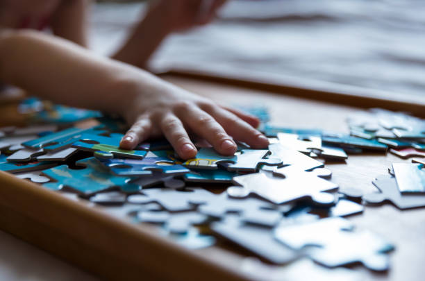 istock Children's hands collect puzzles. An educational game for a kid. 1358030394