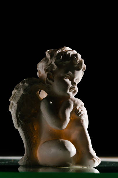 istock White angel against black background 1358030957