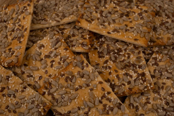 istock cereal cracker, rectangular bread or cookies with seeds and different seeds on a wooden background close-up 1358031883