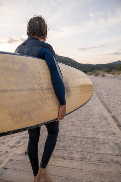 istock Male surfer comes back from surfing 1358031903