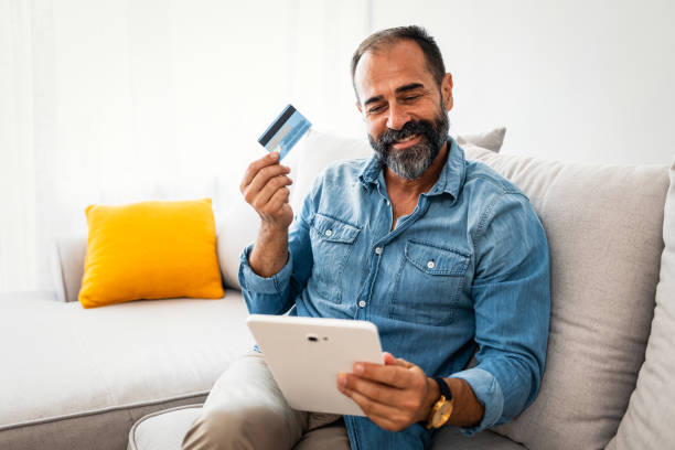 istock Smiling  guy using smart phone to check credit card transactions from app. 1358031907