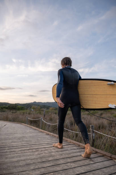 istock Male surfer comes back from surfing 1358031924