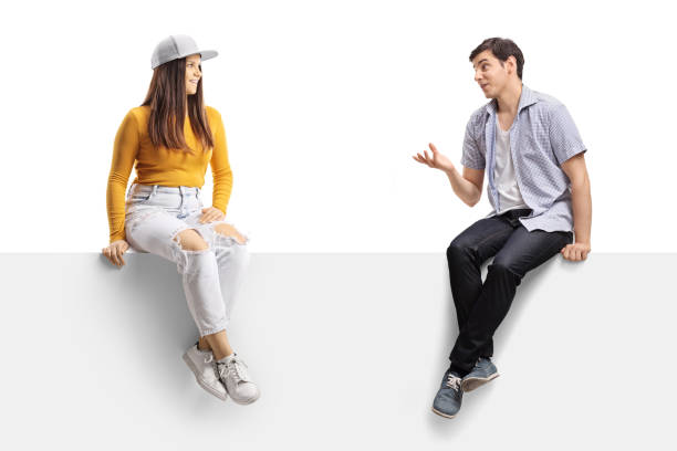 istock Casual young people sitting on a blank panel and having a conversation 1358032283