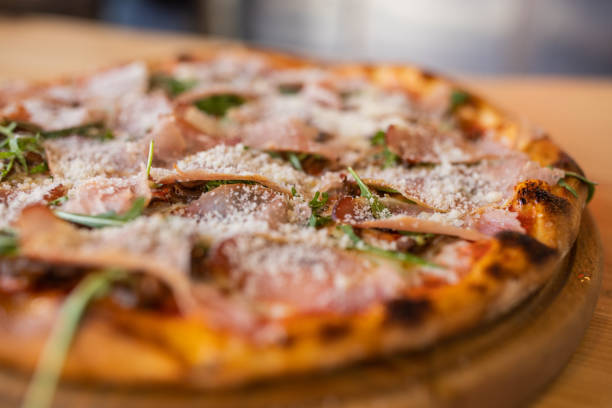 istock Pizza with nice crust and prosciutto, parmesan and arugula 1358032427