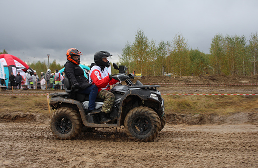 Russia, Novosibirsk 25.09.2021: tourists on ATVs and all-terrain vehicles ride on a dirty road to the race