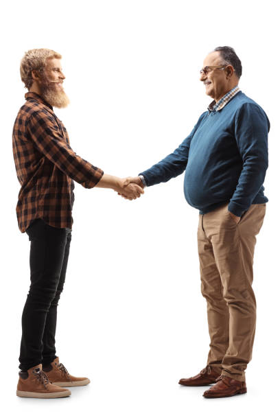 若いひげを生やした男と握手の成熟した男の完全な長さのプロフィールショット - greeting teenager handshake men ストックフォトと画像