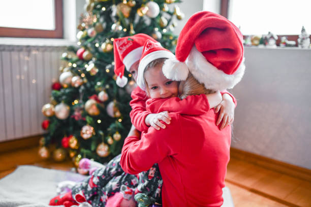 istock Female Children Embracing Mother While Spending Christmas Morning Under Tree 1358036787