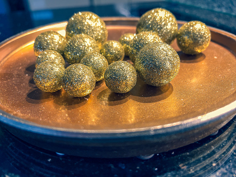 Golden, shiny balls on a golden plate.