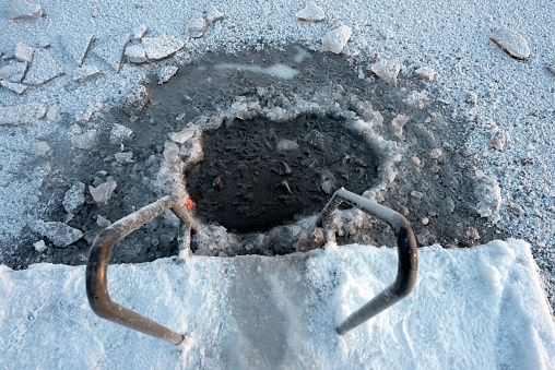 a cut hole in the ice for winter swimming - winter swimming at a jetty in the lake drevviken in tyresö municipality near the city of stockholm