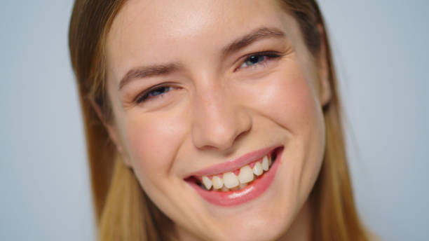 istock Closeup beautiful happy woman smiling on grey background in studio. 1358040652
