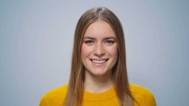 istock Closeup beautiful happy woman smiling at camera on grey background in studio. 1358040967