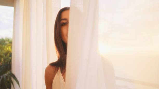 istock Seductive woman hiding behind transparent curtain 1358041183